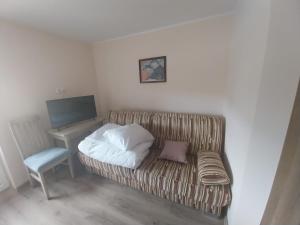 Zimmer mit Sofa, Schreibtisch und TV in der Unterkunft DoTleń Villa in Tleń
