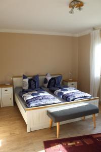 um quarto com uma cama com almofadas azuis e brancas em Steens Huus em Grossenbrode