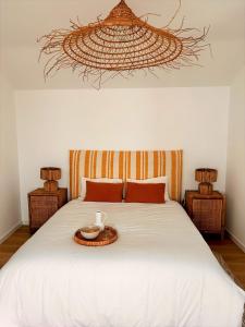 a bedroom with a white bed with a tray on it at Palmeirinha Guest House in Sintra