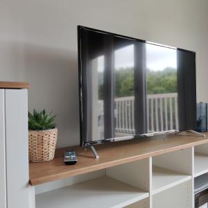 una TV a schermo piatto seduta sulla mensola di Appartamento Nautilus a Lido di Jesolo