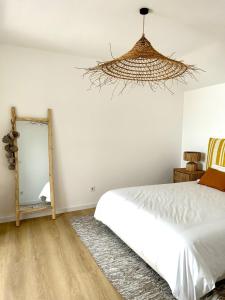 a bedroom with a white bed and a mirror at Palmeirinha Guest House in Sintra