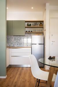 a kitchen with a table and a white refrigerator at Appartamento Nautilus in Lido di Jesolo