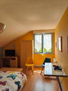 1 dormitorio con cama, escritorio y ventana en A 15 mn ouest Caen, en Noyers-Bocage