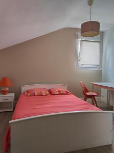 1 dormitorio con 1 cama grande con manta roja en A 15 mn ouest Caen, en Noyers-Bocage