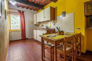 cocina con mesa y sillas en una habitación en La pieve - Mimose, en Pereta