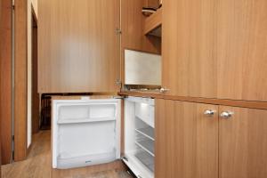 Una pequeña cocina con refrigerador abierto y gabinetes de madera. en Appartamento Bilocale Moneglia 32, en Moneglia