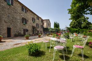 a group of chairs and tables in front of a building at La pieve - Rose in Pereta