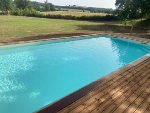una gran piscina con terraza de madera en Il Casale delle Rose en Paganico