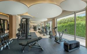 un gimnasio con cintas de correr y elípticas y grandes ventanas en Centara Reserve Samui - SHA Plus, en Chaweng