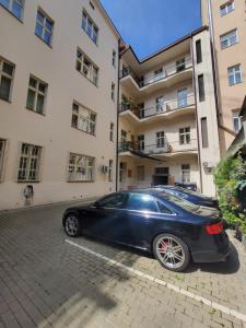 布拉格的住宿－放鬆公寓，停在大楼前的一辆黑色汽车
