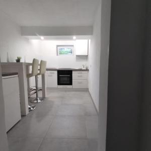 a white kitchen with a table and chairs in it at Monteur-/Ferienwohnung Baden Baden Rastatt Elsass in Hügelsheim