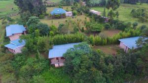 Muga Eco Village في Ntungamo: اطلالة علوية على مزرعة فيها بيوت واشجار