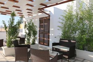 a patio with chairs and a table and some plants at B&B Vacanze Salento in Torre San Giovanni Ugento