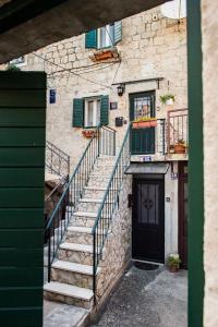 - un bâtiment en pierre avec des escaliers et une porte dans l'établissement Apartments Leticia, à Split