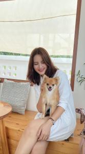 a woman sitting on the floor with a small dog at Topp paiway hostel in Pai