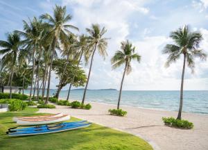 two boats on a beach with palm trees at Centara Reserve Samui in Chaweng +239 photos