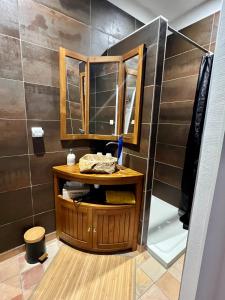 a bathroom with a wooden vanity with a mirror at Les MIRABELLES chambres d'hôtes in Sisteron