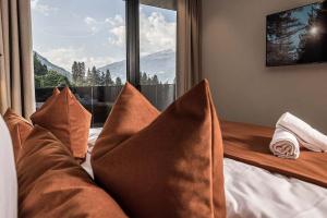 a couch with pillows in a room with a window at Panorama Nature Lodge in Hart im Zillertal