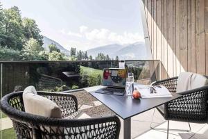 a laptop computer sitting on a table on a balcony at Panorama Nature Lodge in Hart im Zillertal