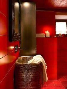 Un baño rojo con un cubo de basura con una toalla. en Castello di Darany,dimore con spa private con Jacuzzi e saune, en Villeneuve