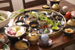 una mesa con muchos platos de comida. en Hanasuishou en Fuefuki