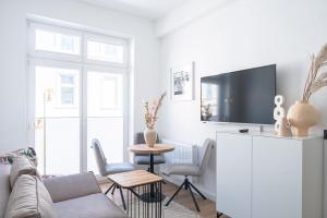 uma sala de estar com um sofá e uma televisão em JOHOUSE Apartment 9 em Warnemünde