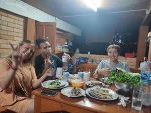 a group of people sitting at a table eating food at Topp paiway hostel in Pai