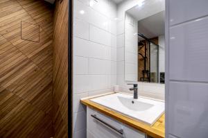 a bathroom with a sink and a mirror at Apartament Panorama in Gdynia