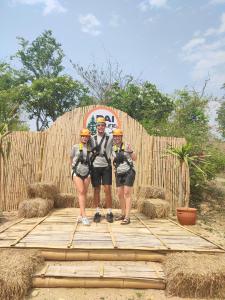 a group of three people standing in front of a fence at Topp paiway hostel in Pai