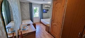 a small room with a bed and a window at Ривер Гагра in Gagra