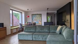 a living room with a green couch and a table at Kubus 28A in Gräfenberg