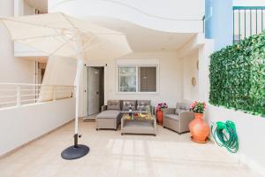een woonkamer met een bank en een paraplu bij Oasis Home Heraklion in Heraklion