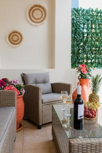 een woonkamer met een tafel met een fles wijn bij Oasis Home Heraklion in Heraklion