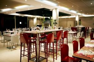 une grande salle à manger avec des tables et des chaises dans l'établissement Campanile Saint-Quentin-En-Yvelines, à Montigny-le-Bretonneux