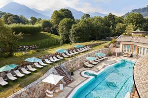 uma vista aérea para uma piscina com cadeiras e guarda-sóis em Grand Tirolia Kitzbühel - Member of Hommage Luxury Hotels Collection em Kitzbühel
