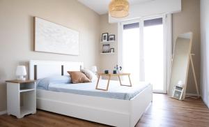 um quarto com uma cama branca e uma mesa em Appartamento Nautilus em Lido di Jesolo