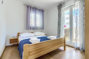 a bedroom with a bed with two towels on it at Beach Dream Apartments in Ivan Dolac