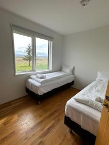 two beds in a room with a window at Brú Country Estate in Selfoss