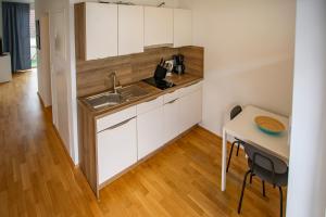 a small kitchen with a sink and a table at Modern Innsbruck Apartment I Free Parking in Innsbruck