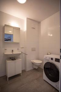 uma casa de banho com uma máquina de lavar roupa e um WC em Modern Innsbruck Apartment I Free Parking em Innsbruck