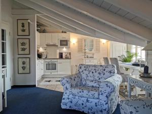 ein Wohnzimmer mit einem Stuhl und eine Küche in der Unterkunft Ferienwohnung Häusler in Fischen im Allgäu