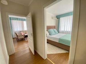 1 dormitorio con 1 cama y 1 habitación con silla en Wild Cherry Apartments, en Saints Constantine and Helena