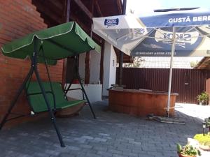 - une chaise verte et un parasol sur la terrasse dans l'établissement Casa Rares Toc, à Vidra