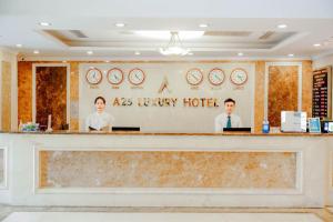 a restaurant with two men standing behind a counter at A25 Luxury Hotel in Hanoi