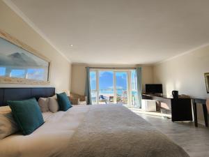 a bedroom with a large bed with a view of the ocean at Hout Bay Breeze in Hout Bay
