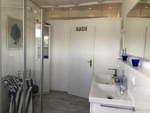 ein weißes Bad mit einem Waschbecken und einer Dusche in der Unterkunft Ferienwohnung Häusler in Fischen im Allgäu