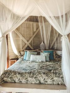 a bedroom with a bed with a canopy at Harmonie in Rivière Noire