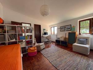 a living room with a couch a chair and a tv at Santa Cruz Beach House in Areias