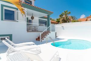 eine Terrasse mit einem Whirlpool und Stühlen vor einem Haus in der Unterkunft Villa Veaco Beach with jacuzzi and private pool in Corralejo
