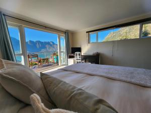 a bedroom with a large bed with a large window at Hout Bay Breeze Guest House in Hout Bay